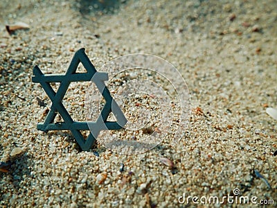 Jewish star like piece of plastic waste in the sand of the sea beach Stock Photo