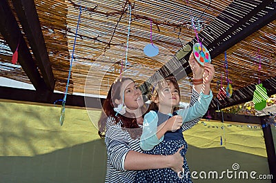 Jewish woman and child decorating their family Sukkah Stock Photo