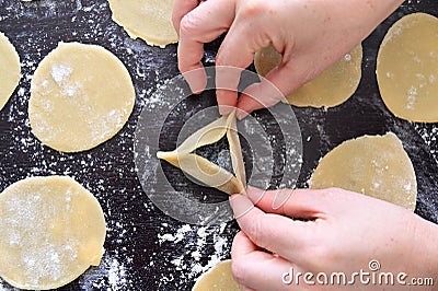 Jewish woman preparing the first Hamantash cookie for Purim Jewish holiday Stock Photo