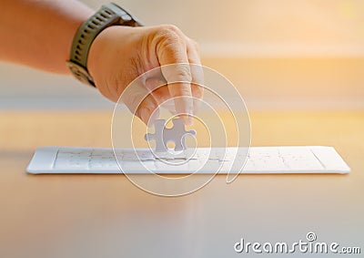Jigsaw puzzle pieces on palm Pieces of jigsaw puzzle in man hands and one is highlighted Stock Photo