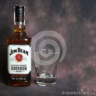 Jim Beam whiskey bottle and a glass for whiskey on dark vintage background Editorial Stock Photo