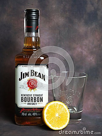 Jim Beam whiskey bottle, half lemon and a glass for whiskey on dark vintage background Editorial Stock Photo