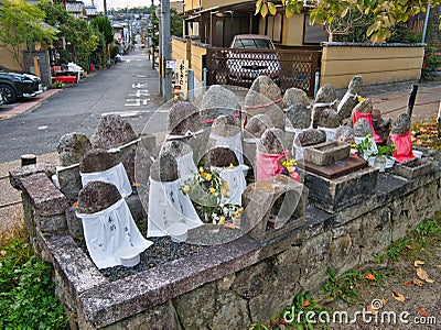 Jizo statues with inscribed white cloth aprons along the Philosophers` Walk in Kyoto, Japan Editorial Stock Photo