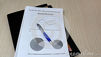 Job with finances in the office on a laptop,the employee holds paper with the inscription business plan. Busines starting business Stock Photo