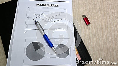 Job with finances in the office on a laptop ,the employee holds paper with the inscription business. pen and business growth chart Stock Photo