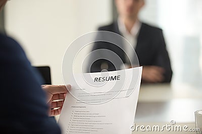 Job interview in office, focus on resume, close up view Stock Photo