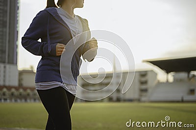 Young women warm up body. Sit back and Drink whey protein rest after running jogging on the running track around the football fie Stock Photo
