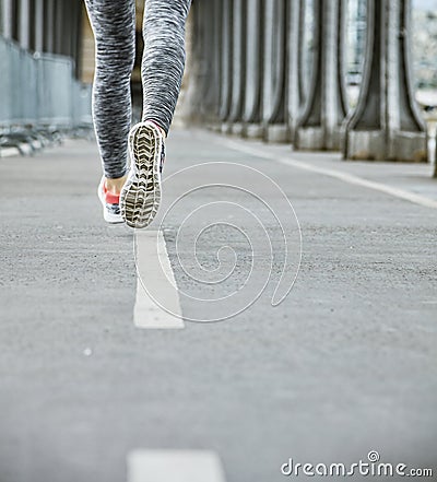 Closeup on woman jogger running on Pont de Bir-Hakeim bridge Stock Photo