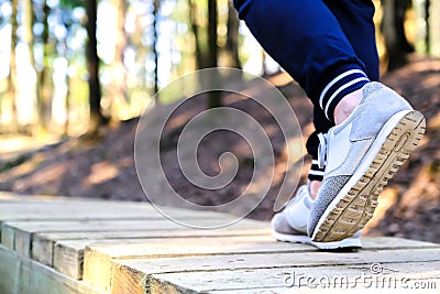 Jogging in sneakers on the bridge in the Park. Sport, Health and physical culture concept Stock Photo