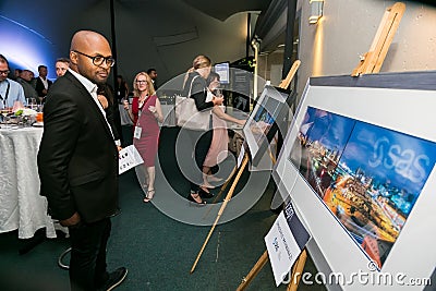 Diverse people looking at painting in art gallery Editorial Stock Photo