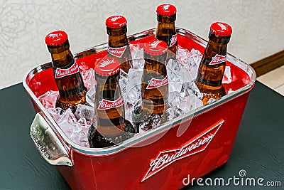 Budweiser bottles of beer in red branded ice bucket on bar counter Editorial Stock Photo