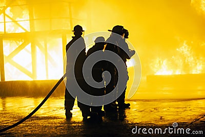 JOHANNESBURG, SOUTH AFRICA - MAY, 2018 Group of firefighters standing in front of fire during fighting training exercise Editorial Stock Photo