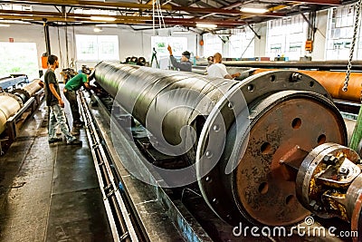 Diverse workers inside a rubber and pipe fabrication assembly line in a factory Editorial Stock Photo