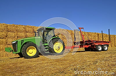 John Deere tractor and trailer by bale stack Editorial Stock Photo