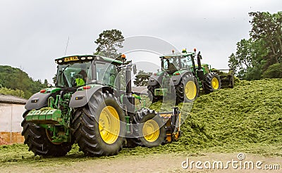 John Deere tractors pushing silage at the clamp Editorial Stock Photo