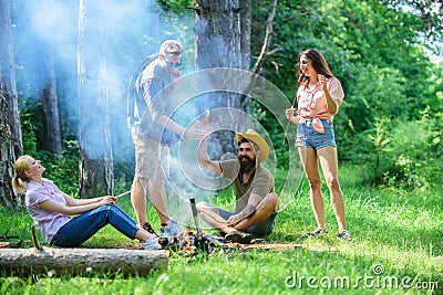 Join summer picnic. Company having fun while roasting sausages on sticks. Gathering for great picnic. Friends meeting Stock Photo