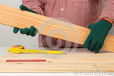 joiner measuring a wooden plank with tape measure yellow on the work-table for construction, carpenter Use tool checking accuracy Stock Photo