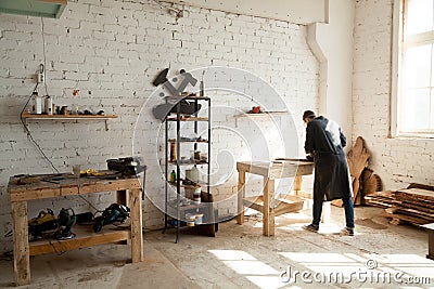 Joiner working at workbench in small carpentry Stock Photo