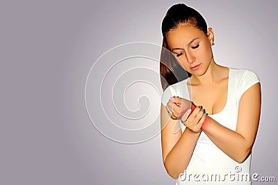 Joint pain. Young woman suffer with wrist pain. Sprain pain location indicated by red spot. Stock Photo