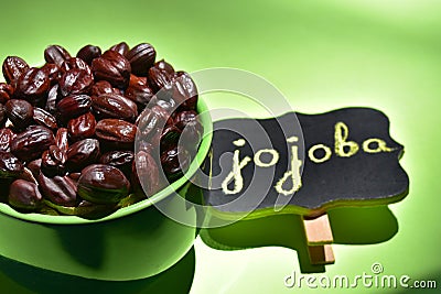 Jojoba seeds in a green bowl Stock Photo