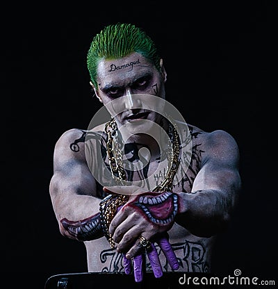 Joker from a Suicide Squad comics on a black background. Professional make-up Editorial Stock Photo