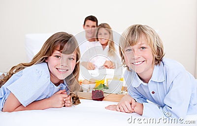 Jolly family having breakfast sitting on bed Stock Photo