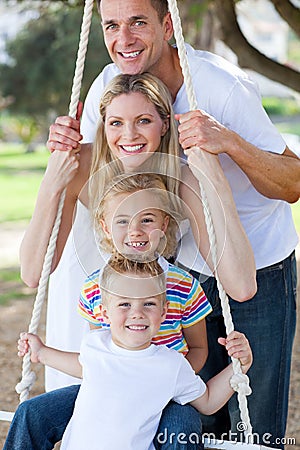 Jolly family swinging Stock Photo