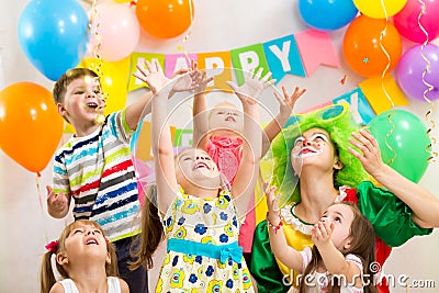 Jolly kids group with clown celebrating birthday Stock Photo