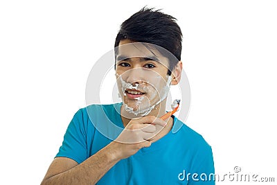 Jolly nice guy with black hair shaves his beard and looks into a camera isolated on a white background Stock Photo