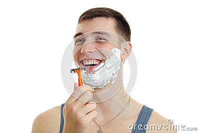 Jolly nice guy with foam beard holds in his hand shaving machine and laughs is isolated on a white background Stock Photo