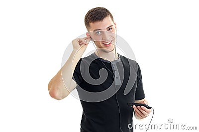 Jolly nice guy inserts the earpiece into your ear and listens to music close-up Stock Photo