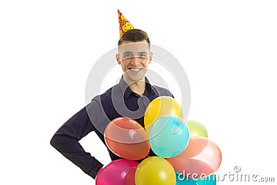 Jolly nice guy looks into the camera and holds in his hand a lot of colorful balloons Stock Photo