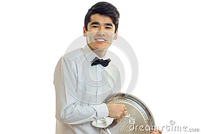 Jolly nice waiter in a white shirt and with a butterfly holds in his hand a tray close-up Stock Photo