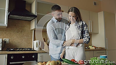 Jonge mens die meisjesogen behandelen met handen en haar thuis verrassen in de keuken stock footage Jonge mens die meisjesogen behandelen met handen en haar thuis verrassen in de keuken stock footage