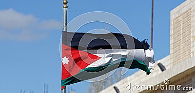 Jordanian flag waving in the wind in front of the tourist centre and visitor centre near the crusader castle in Karak, Jordan Stock Photo