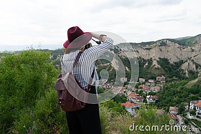 Journalist on a viewpoint taking a photo of the sightseeing of an old town in the balkan. Blogger on a hill photographing a rocky Stock Photo