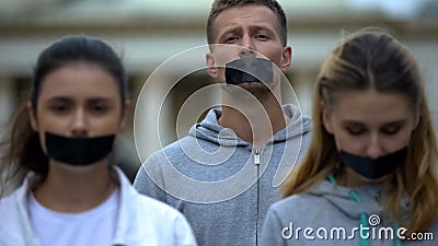 Journalists having taped mouth, violation of speech freedom, corruption bribery Stock Photo