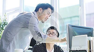 Joven empresario asiático que recibe ayuda de un colega metrajes Joven empresario asiático que recibe ayuda de un colega metrajes