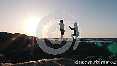 Joven tÃmido haciendo una oferta a su querida chica en la orilla del mar al atardecer. Un hombre atractivo de pie sobre su rodill Joven tÃmido haciendo una oferta a su querida chica en la orilla del mar al atardecer. Un hombre atractivo de pie sobre su rodill