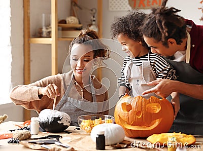 Joyful african american family mother, father and boy son enjoying Halloween preparation at home Stock Photo
