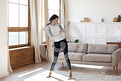 Joyful black woman dancing in living room Stock Photo