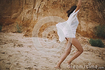 Joyful boho girl in white summer dress walking on beach. Carefree young woman relaxing on seashore. Summer vacation. Mindfulness Stock Photo