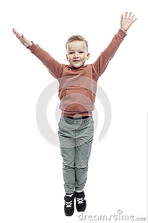 The joyful boy raised his hands up. A blond guy in a brown hoodie and gray trousers. Positivity and happiness. Isolated on white Stock Photo