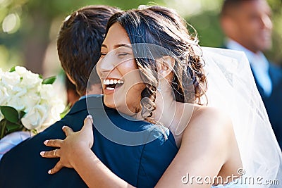 Joyful bride hugging groom. Beautiful young mixed race woman looking happy after marrying her soulmate Stock Photo