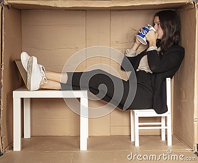 Joyful busiesswoman is sitting in the carbonaceous office, drinking coffee Stock Photo