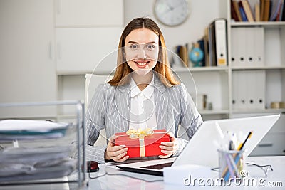 Joyful business woman with gift box in office Stock Photo
