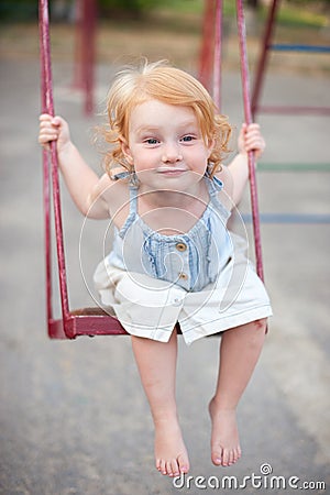 Joyful child swinging on a swing Stock Photo