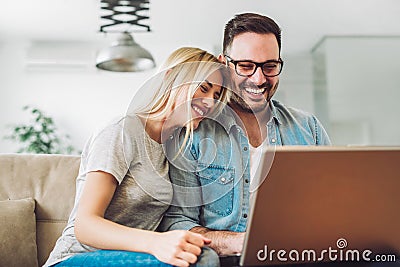 Joyful couple relax and work on laptop computer at modern living room Stock Photo