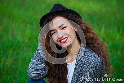 Joyful, curly-haired woman in a hat Stock Photo