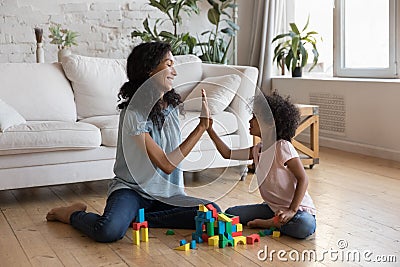 Joyful excited African mom and little kid celebrating playing achieve Stock Photo